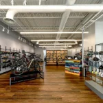Spacious bike shop interior with bicycle displays, accessory walls, custom shelving systems, LED lighting, and exposed ceiling design in Atlanta retail space