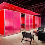 Innovative tattoo treatment pods featuring red translucent panels, modern lounge seating, neon signage, and contemporary black furniture in Atlanta location