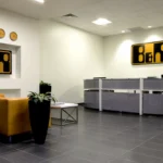 Contemporary industrial office reception by Cornerstone, commercial construction company Atlanta, featuring branded elements and modern furniture