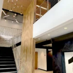 Interior view showcasing modern staircase, wood slat column, and custom lighting fixtures demonstrating CCG's attention to architectural details