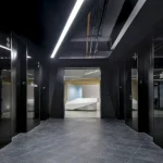 Dramatic black corridor with modern lighting, custom signage, and polished floor tiles demonstrating CCG's attention to architectural detail